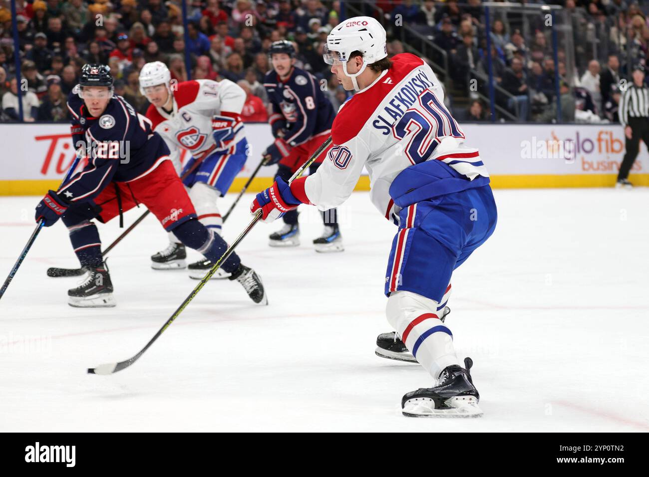 Montreal Canadiens forward Juraj Slafkovsky, right, shoots the puck in front of Columbus Blue Jackets defenseman Jordan Harris during the first period of an NHL hockey game in Columbus, Ohio, Wednesday, Nov. 27, 2024. Slafkovsky scored on the play. (AP Photo/Paul Vernon) Banque D'Images