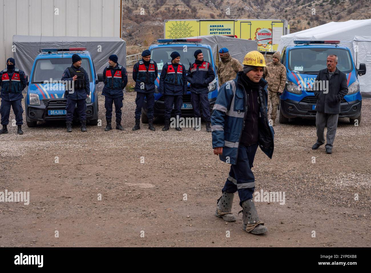 Des unités de gendarmerie prenant des mesures de sécurité sur le site de la grève et un mineur marchant devant elles. Les travailleurs de la mine de lignite-charbon du district de Nall?han/Çay?rhan à Ankara, à 160 kilomètres du centre d'Ankara, propriété de la société turque de production-transmission d'électricité, ont partiellement ralenti les travaux en raison de la privatisation prévue de la mine. Selon les lois de la République de Turquie, les personnes travaillant dans une organisation stratégique n'ont pas le droit de grève. Alors que les mineurs n’interviennent que dans des situations d’urgence, un groupe de mineurs continue leur action par no Banque D'Images