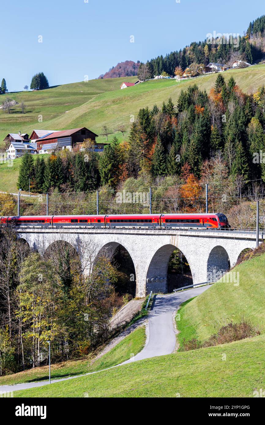 Dalaas, Autriche - 30 octobre 2024 : train de voyageurs Railjet des chemins de fer fédéraux autrichiens ÖBB sur la ligne de chemin de fer Arlberg en automne dans les Alpes autrichiennes Banque D'Images Dalaas, Autriche - 30 octobre 2024 : train de voyageurs Railjet des chemins de fer fédéraux autrichiens ÖBB sur la ligne de chemin de fer Arlberg en automne dans les Alpes autrichiennes Banque D'Images