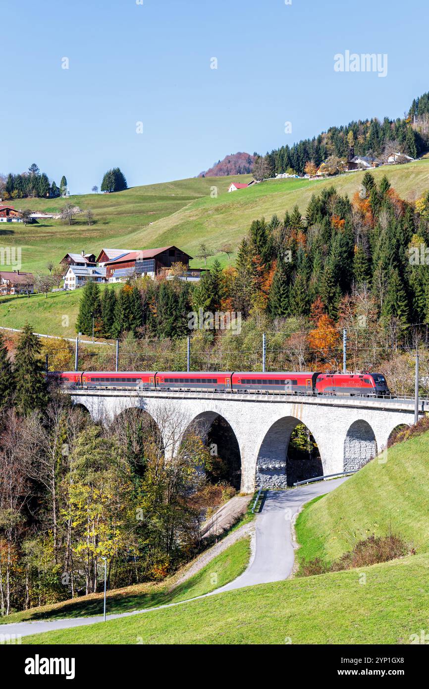 Dalaas, Autriche - 30 octobre 2024 : train de voyageurs Railjet des chemins de fer fédéraux autrichiens ÖBB sur la ligne de chemin de fer Arlberg en automne dans les Alpes autrichiennes Banque D'Images Dalaas, Autriche - 30 octobre 2024 : train de voyageurs Railjet des chemins de fer fédéraux autrichiens ÖBB sur la ligne de chemin de fer Arlberg en automne dans les Alpes autrichiennes Banque D'Images