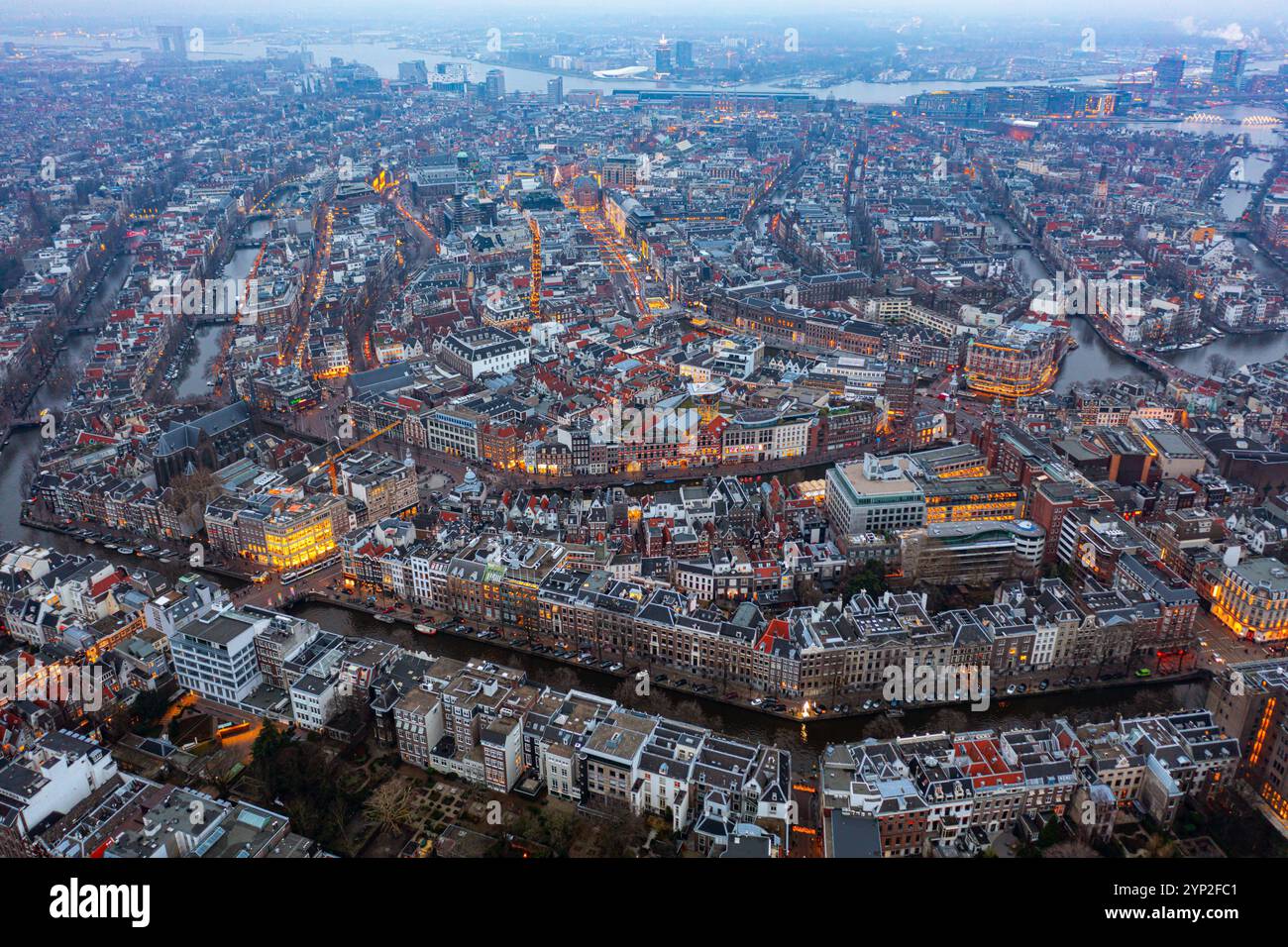 Vue aérienne captivante d'Amsterdam au crépuscule, mettant en évidence les canaux lumineux, l'architecture historique et l'énergie urbaine vibrante de la capitale néerlandaise Banque D'Images