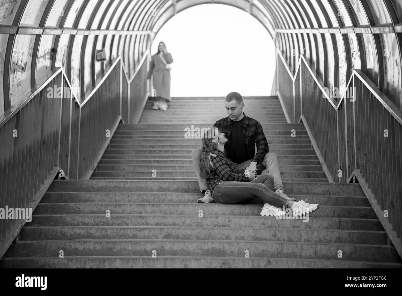 Couple romantique appréciant les uns les autres Compagnie sur un escalier dans un cadre noir et blanc. Banque D'Images