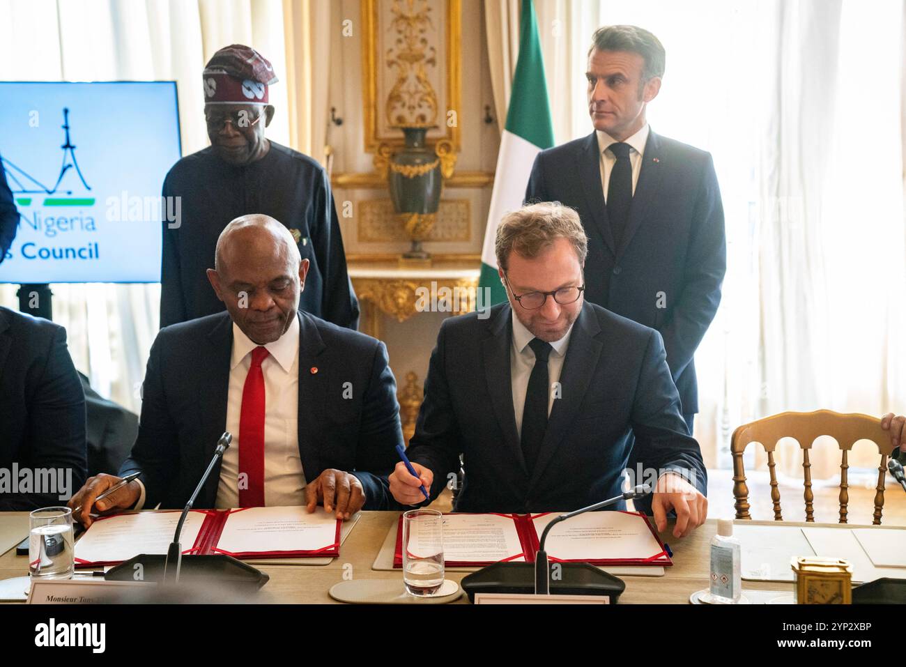 Paris, France. 28 novembre 2024. Le ministre français de l'économie, des Finances et de l'industrie Antoine Armand (2ndR) et Tony Elumelu président de United Bank for Africa (UBA) (assis, à gauche) signent un accord économique, tandis que le président français Emmanuel Macron (à droite) et le président nigérian Bola Ahmed Tinubu se rencontrent lors d'une rencontre avec le président nigérian et sa délégation à l'hôtel Marigny à Paris, le 28 novembre 2024. Photo de Gabrielle Cezard/Pool/ABACAPRESS. COM Credit : Abaca Press/Alamy Live News Banque D'Images