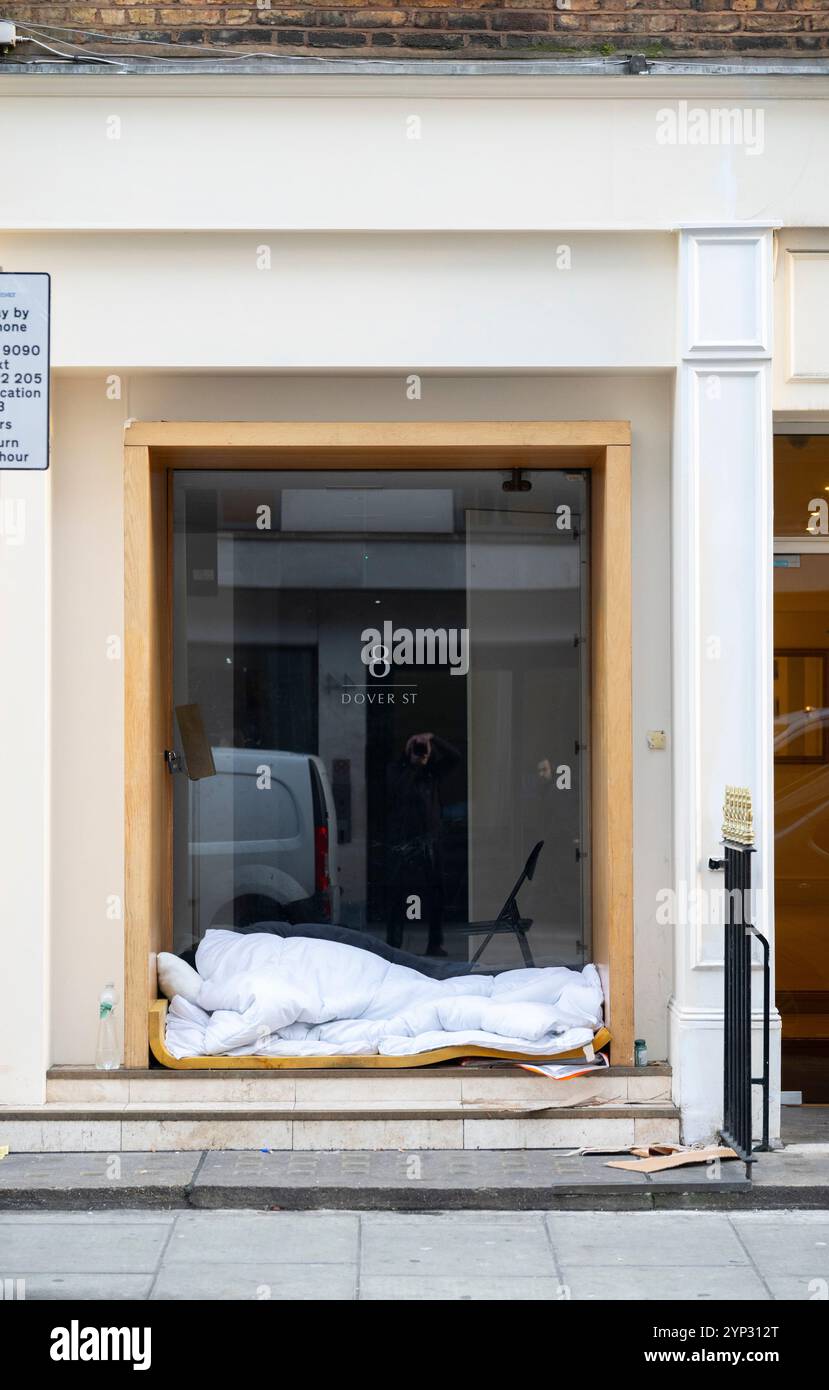 Un sans-abri dormant dans des températures glaciales, porte d'entrée de la propriété à Dover Street, Mayfair, Londres, Royaume-Uni, 28 novembre 2024 Banque D'Images