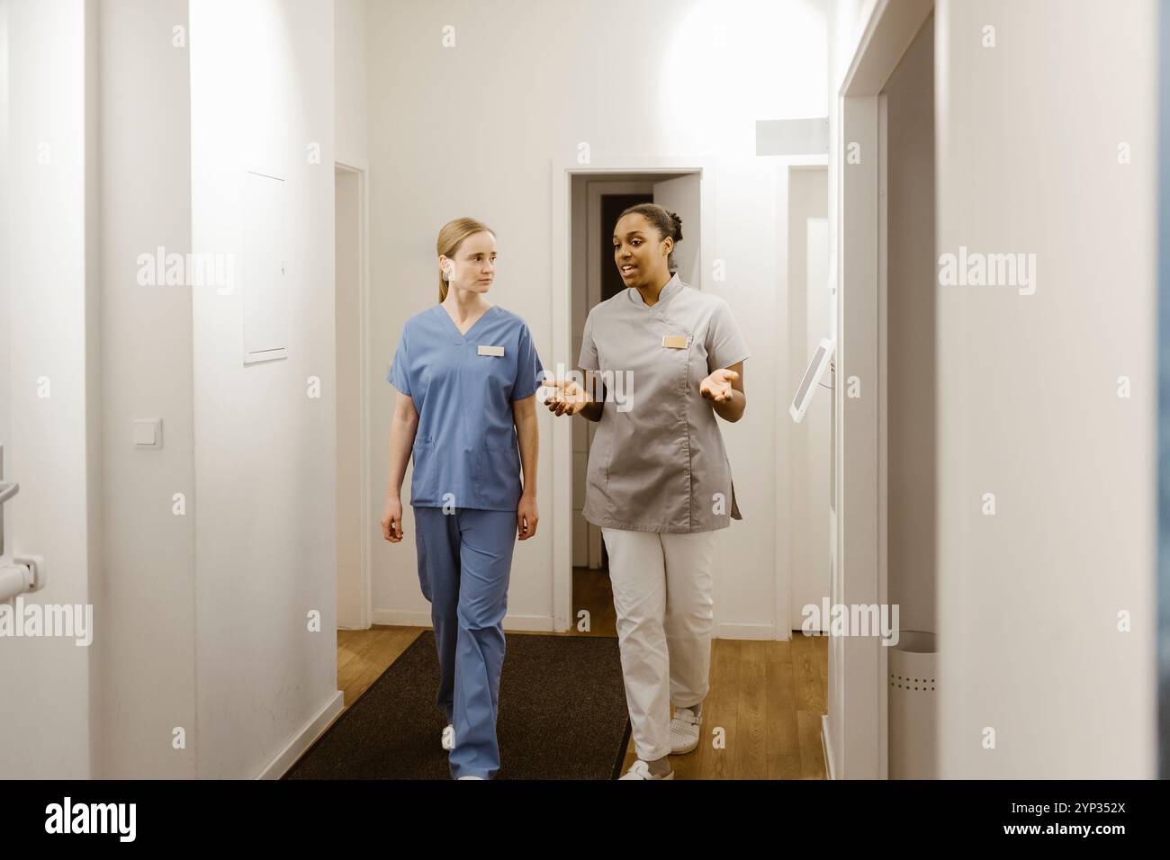 Professionnelle médicale féminine parlant avec un collègue tout en marchant dans le couloir Banque D'Images