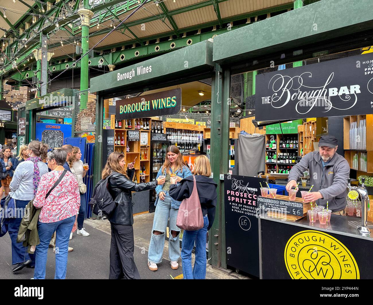 Londres, Angleterre, Royaume-Uni - 3 juillet 2024 : les gens posent avec un verre à l'extérieur d'un stand de vin au Borough Market dans le centre de Londres Banque D'Images