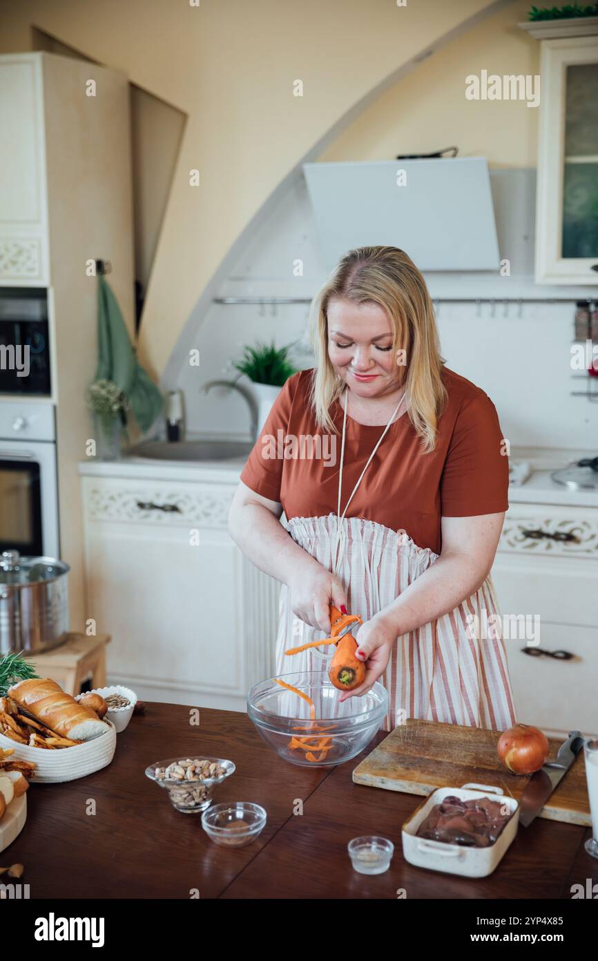 Femme au foyer cuisinier cuisiner salade de légumes dans la cuisine par poêle Banque D'Images