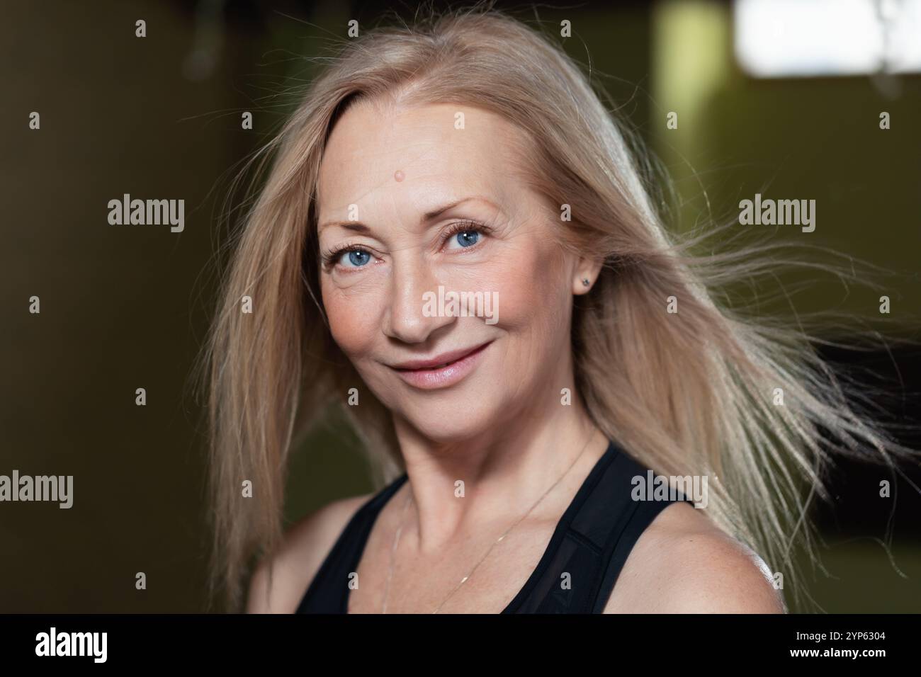 Portrait d'une femme blonde confiante avec des yeux bleus regardant la caméra, femme d'âge moyen posant devant la caméra avec le sourire sur le visage, gros plan Banque D'Images