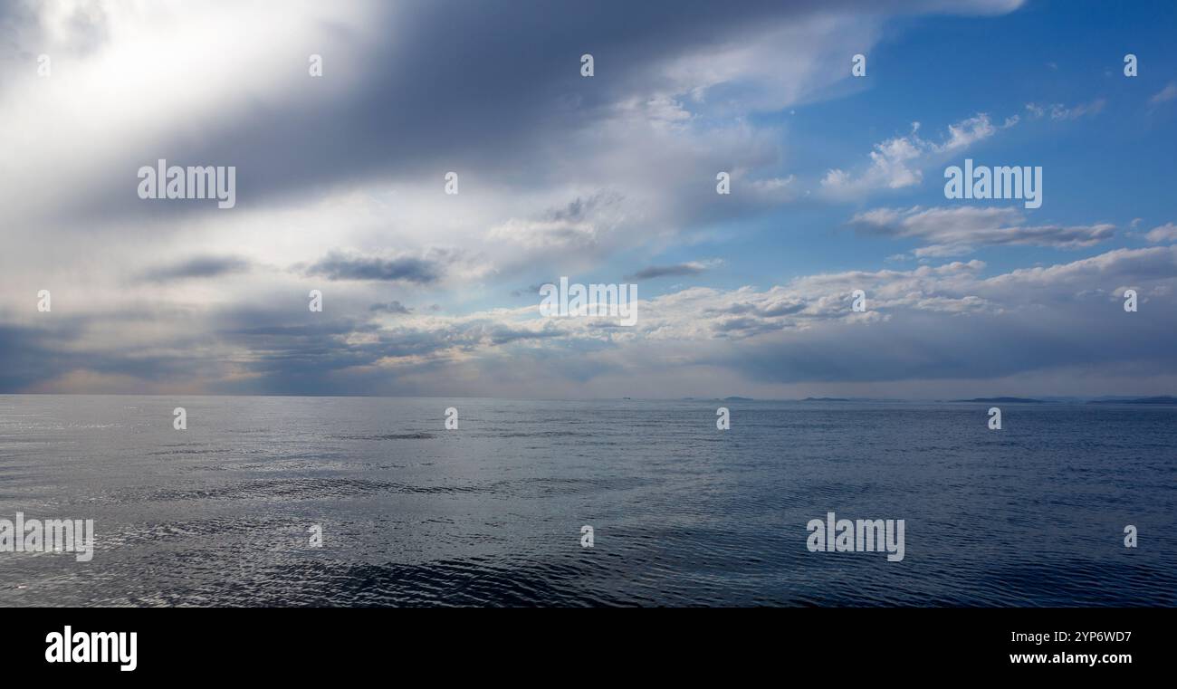 Seascape. Ciel bleu nuageux par une journée ensoleillée au-dessus de la mer. Ciel et rayons de soleil qui brillent à travers les nuages. Banque D'Images