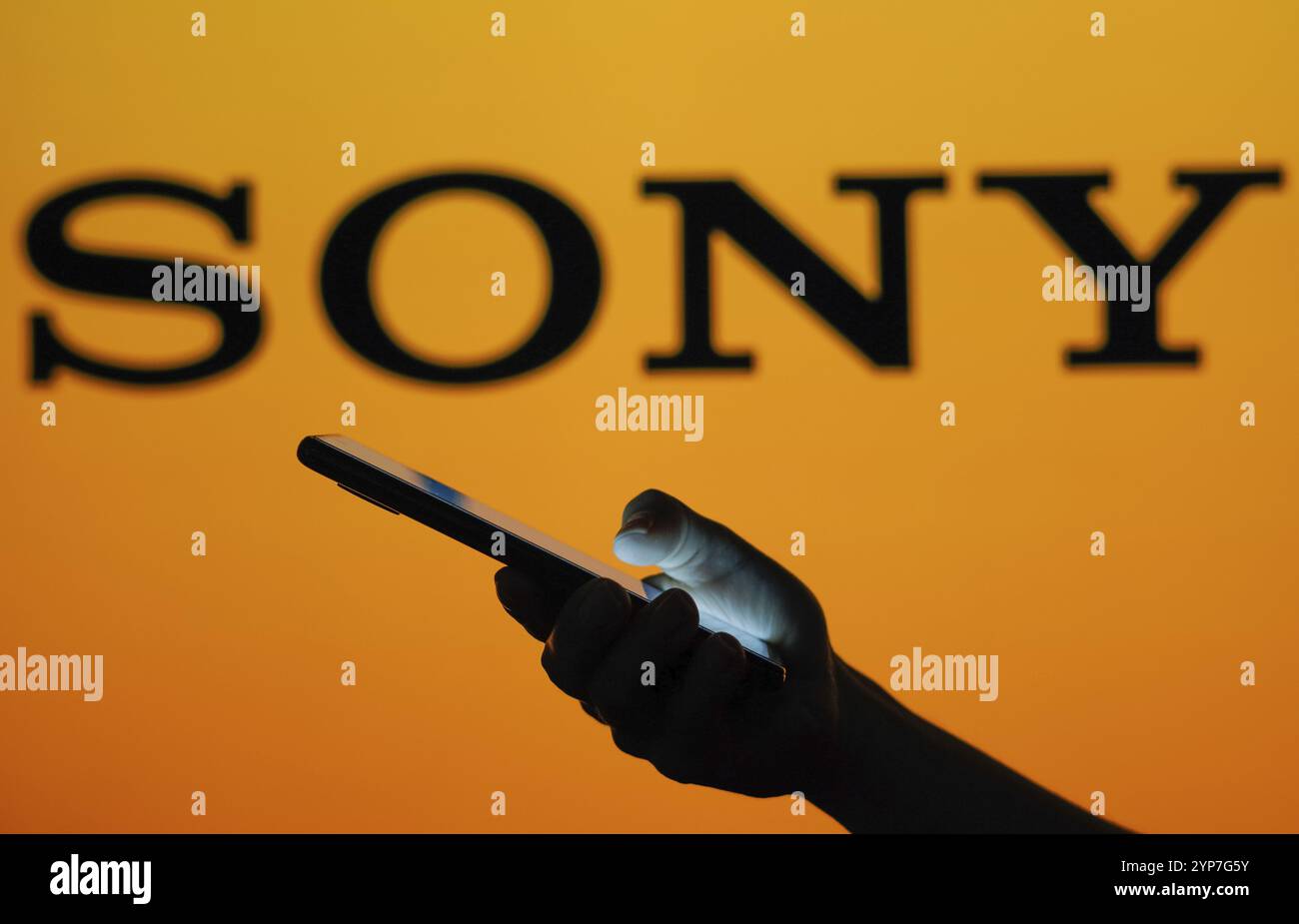 Dans cette illustration photo, le logo Sony vu dans le fond d'une silhouette de femme tenant un téléphone portable Banque D'Images