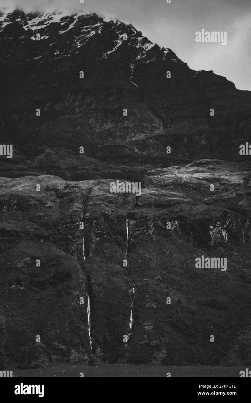 Image en noir et blanc d'une énorme montagne avec des cascades et un pic enneigé, Cattle Flat, Wanaka, Nouvelle-Zélande, Océanie Banque D'Images