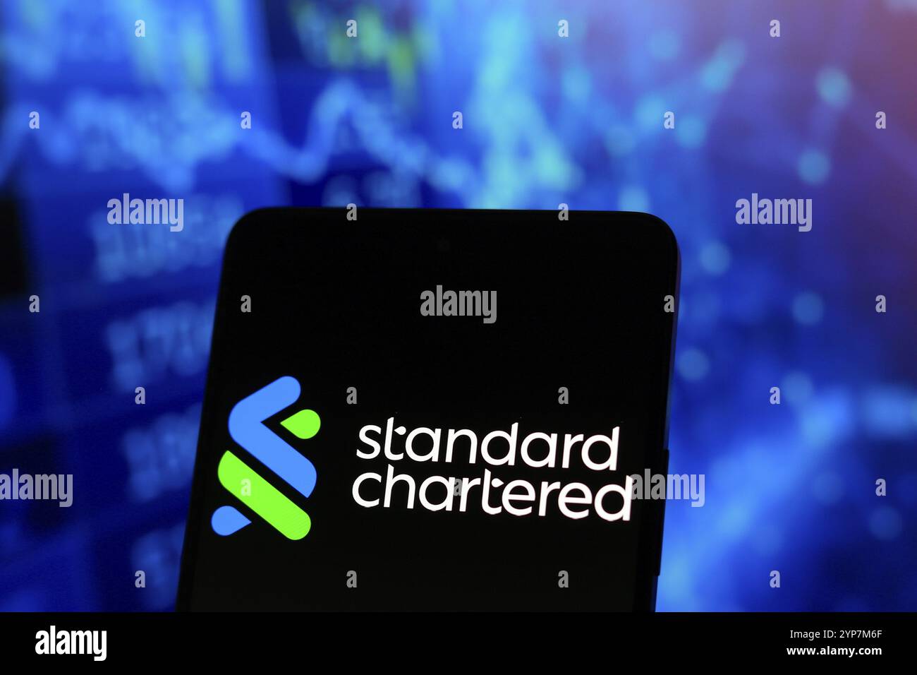 Dans cette illustration photo, le logo Standard Chartered est affiché sur l'écran d'un smartphone Banque D'Images