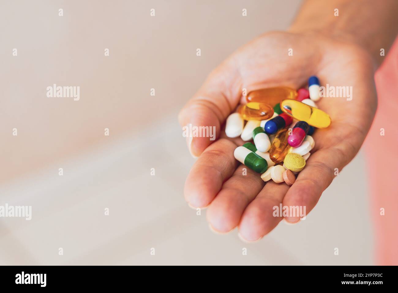 Une personne tient plusieurs pilules de médicaments dans sa main Banque D'Images