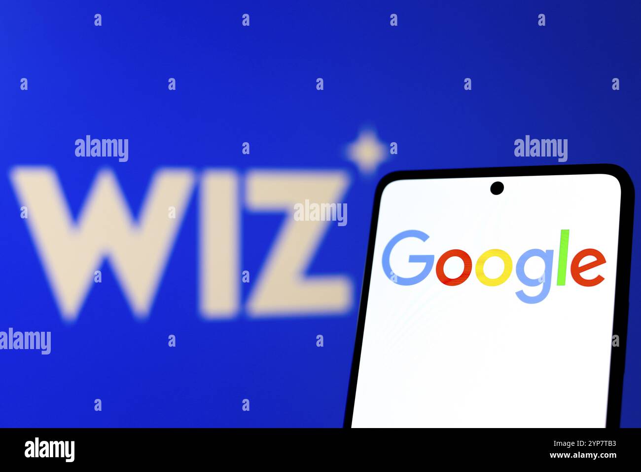 Dans cette illustration photo, le logo Google est affiché sur l'écran d'un smartphone, en arrière-plan le logo Wiz Banque D'Images