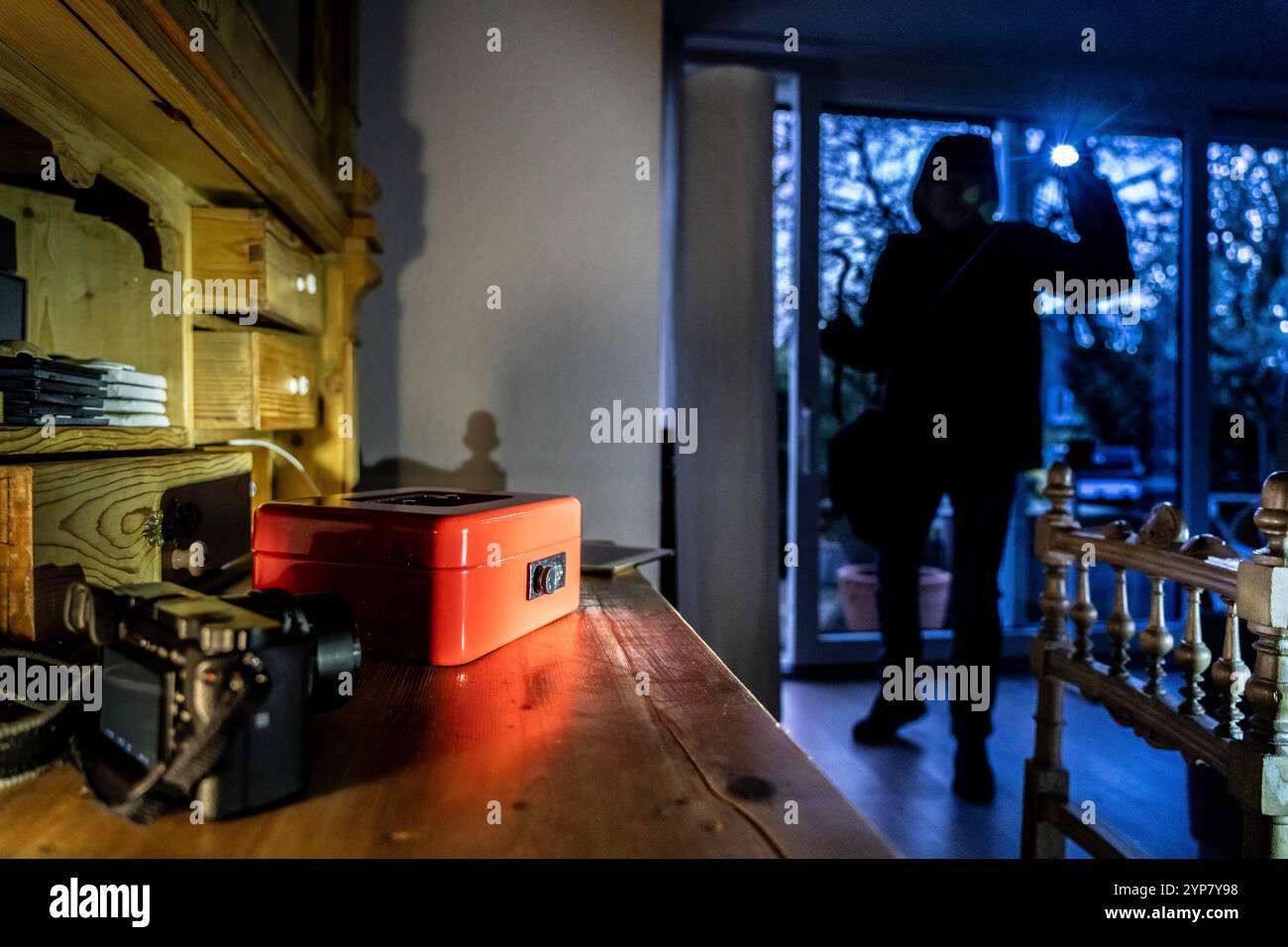 Image symbolique d'un cambriolage, l'auteur est entré par effraction dans un appartement du côté du jardin et est à la recherche de butin, caisse, objets de valeur, argent, tec Banque D'Images