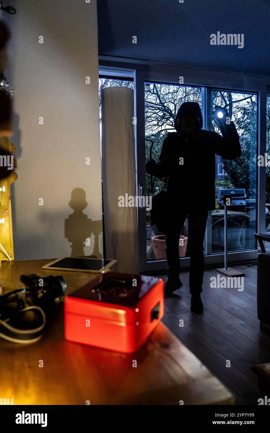 Image symbolique d'un cambriolage, l'auteur est entré par effraction dans un appartement du côté du jardin et est à la recherche de butin, caisse, objets de valeur, argent, tec Banque D'Images