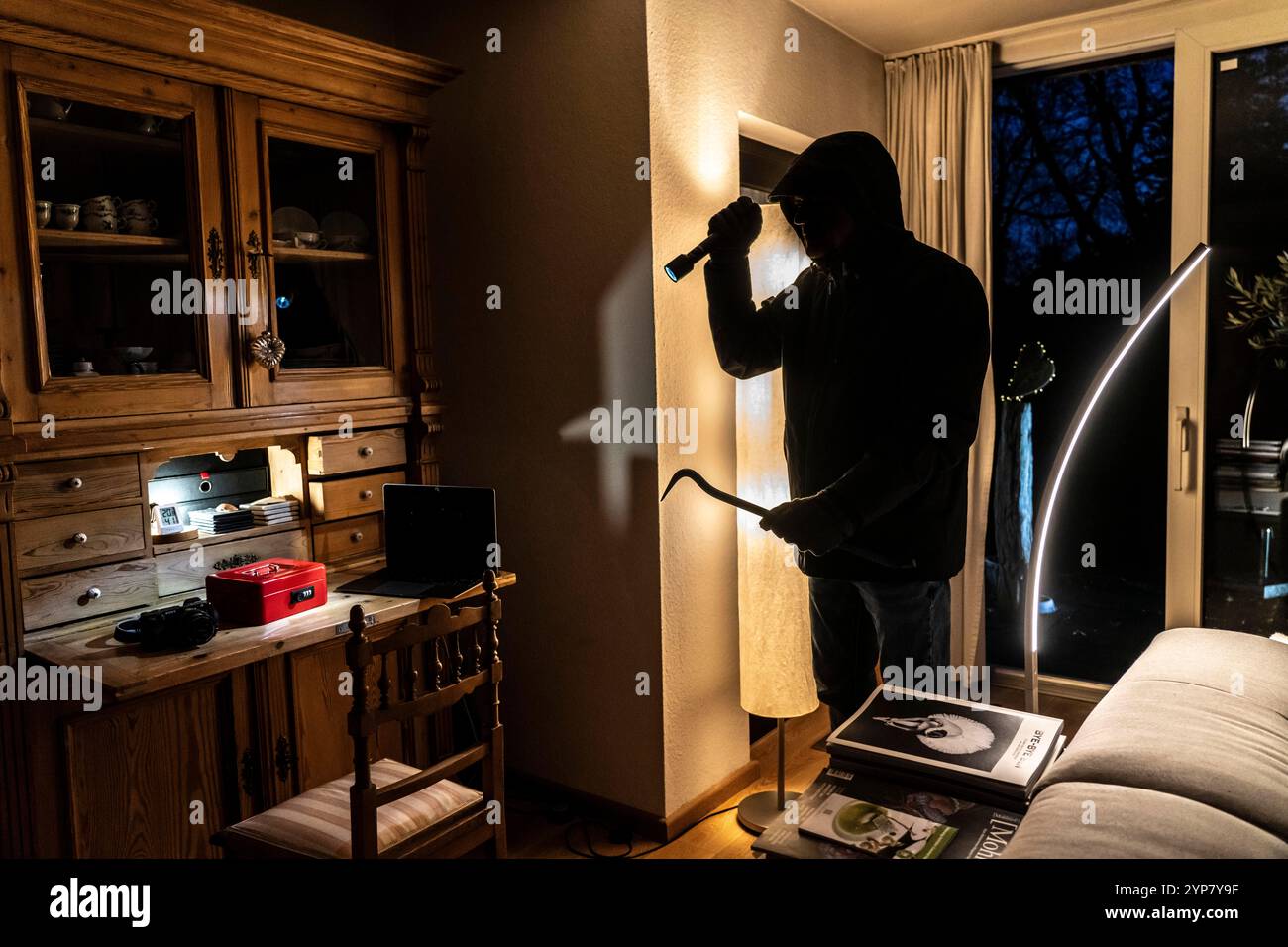 Image symbolique d'un cambriolage, l'auteur est entré par effraction dans un appartement du côté du jardin et est à la recherche de butin, caisse, objets de valeur, argent, tec Banque D'Images