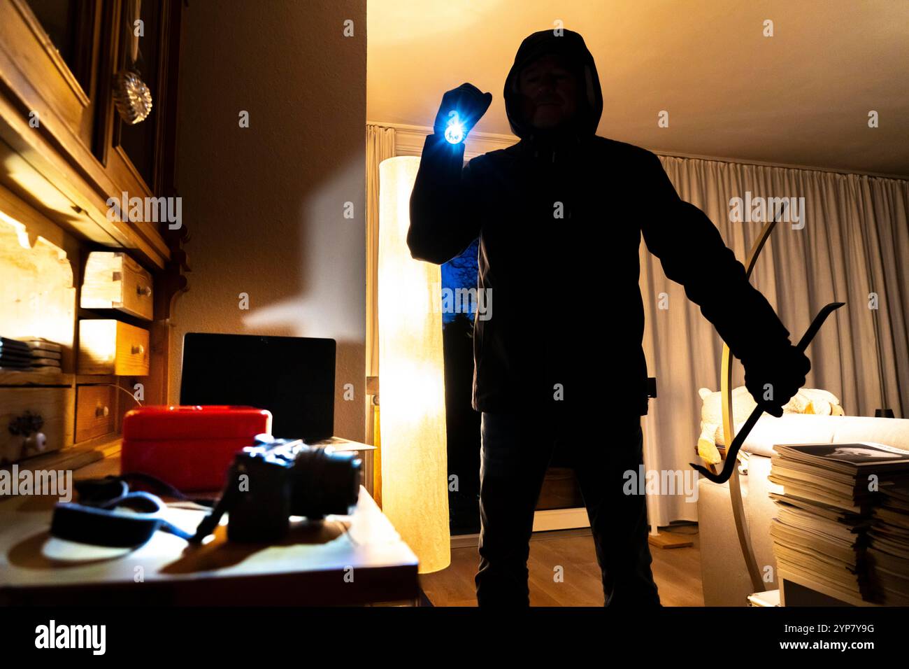 Image symbolique d'un cambriolage, l'auteur est entré par effraction dans un appartement du côté du jardin et est à la recherche de butin, caisse, objets de valeur, argent, tec Banque D'Images