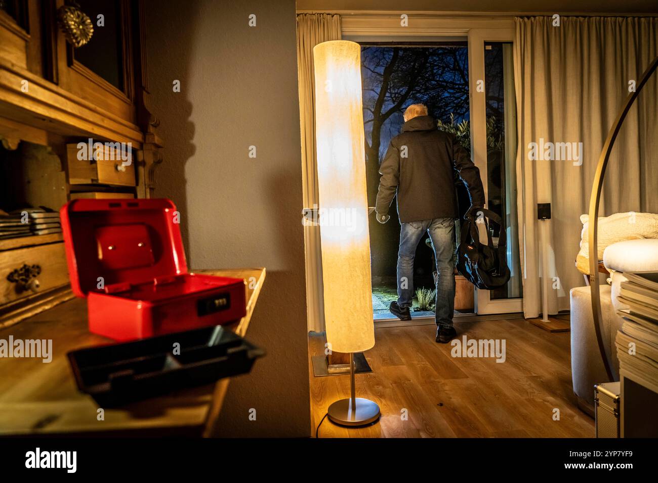 Image symbolique d'un cambriolage, l'auteur est entré par effraction dans un appartement du côté du jardin et a cassé une caisse, trouve des objets de valeur, de l'argent, Banque D'Images