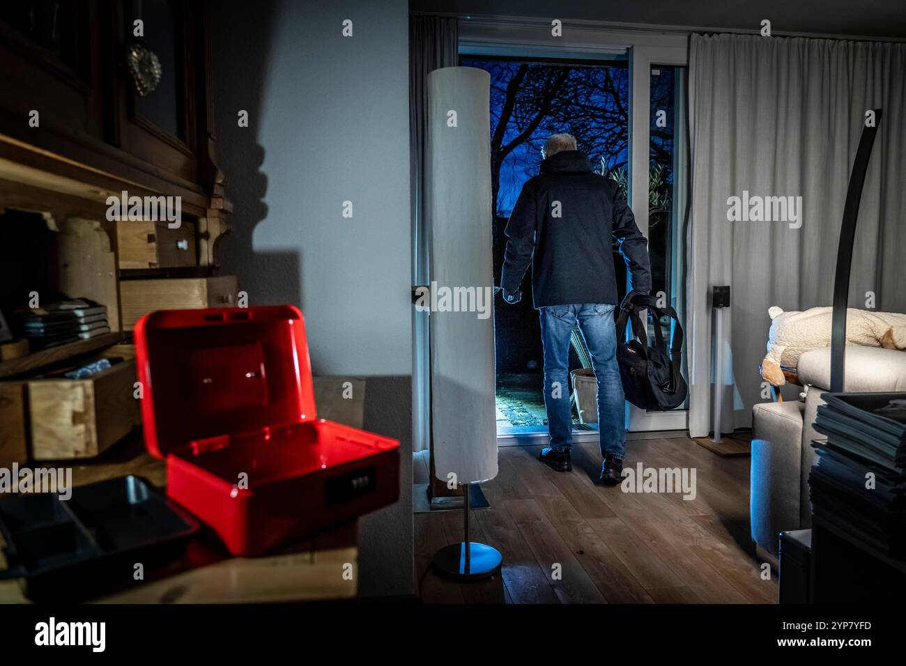 Image symbolique d'un cambriolage, l'auteur est entré par effraction dans un appartement du côté du jardin et a cassé une caisse, trouve des objets de valeur, de l'argent, Banque D'Images