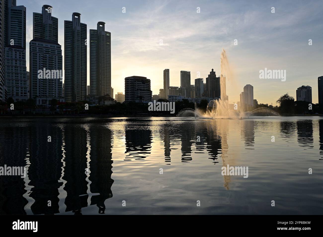 Le soleil du matin se reflétait dans la fontaine du lac Ratchada dans le parc Benjakitti, une destination populaire pour les loisirs en plein air et l'exercice à Bangkok Banque D'Images