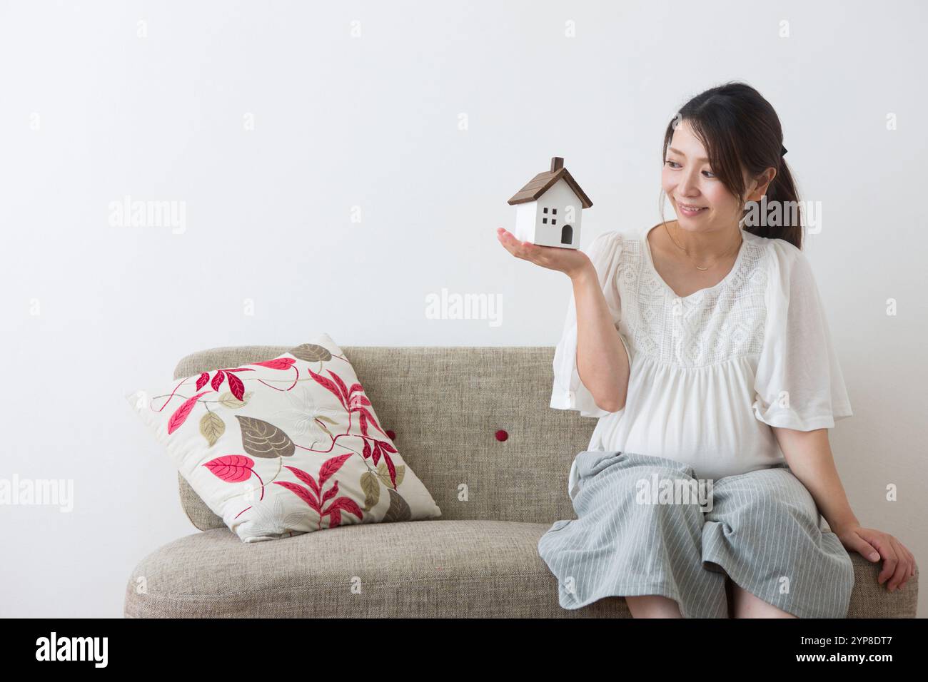 Femme enceinte regardant les jouets de la maison Banque D'Images