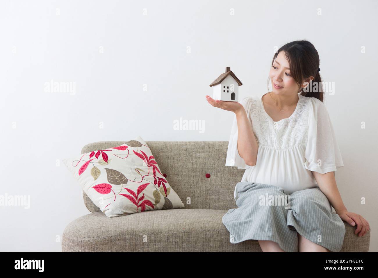 Femme enceinte regardant les jouets de la maison Banque D'Images