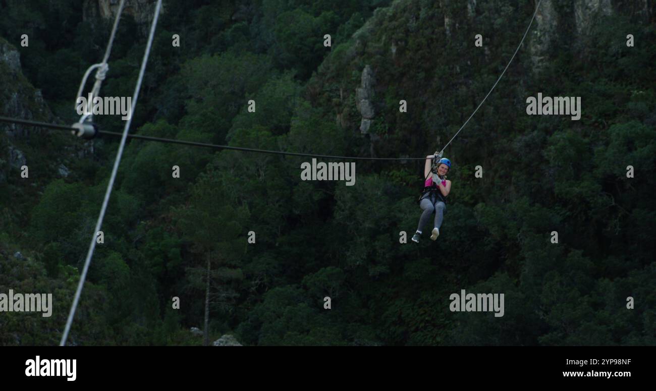 Vue arrière d'une jeune femme caucasienne fermeture éclair sur une journée ensoleillée dans les montagnes, ralenti Banque D'Images