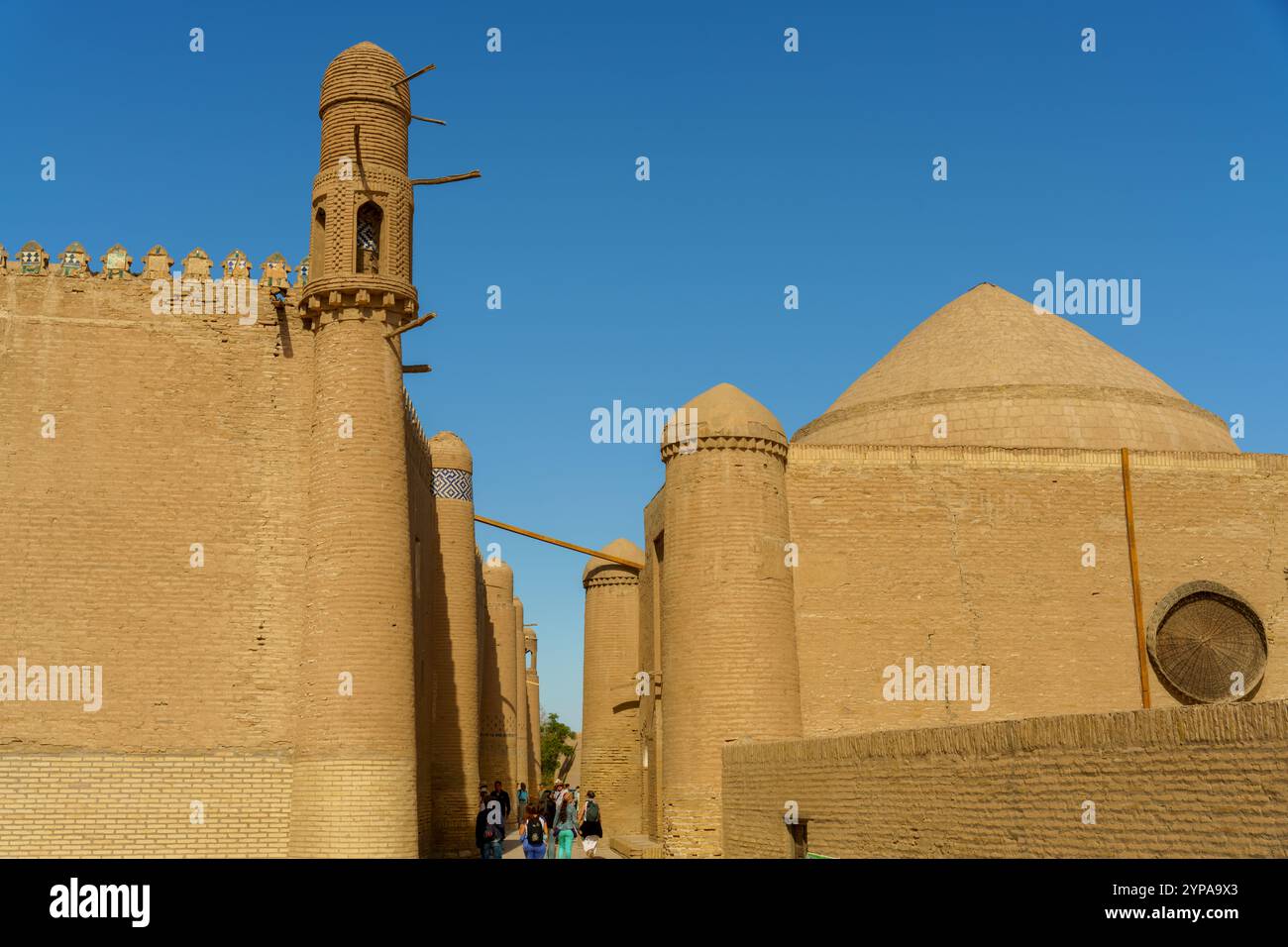 Un groupe de personnes marchent dans une rue étroite devant Banque D'Images