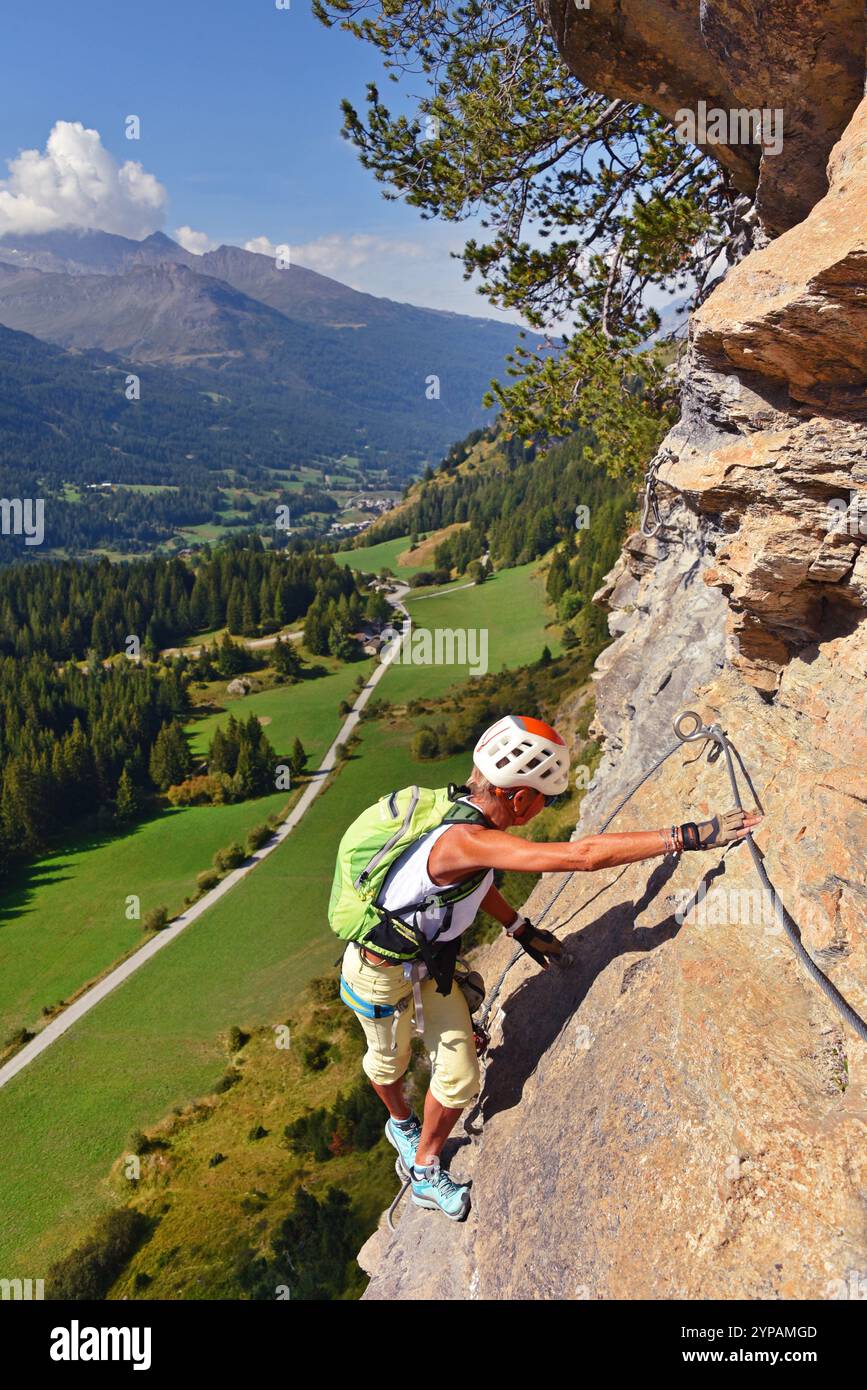 Grimpeur montant une paroi rocheuse abrupte, via Ferrata du Col de la Madeleine, France, Savoie Banque D'Images