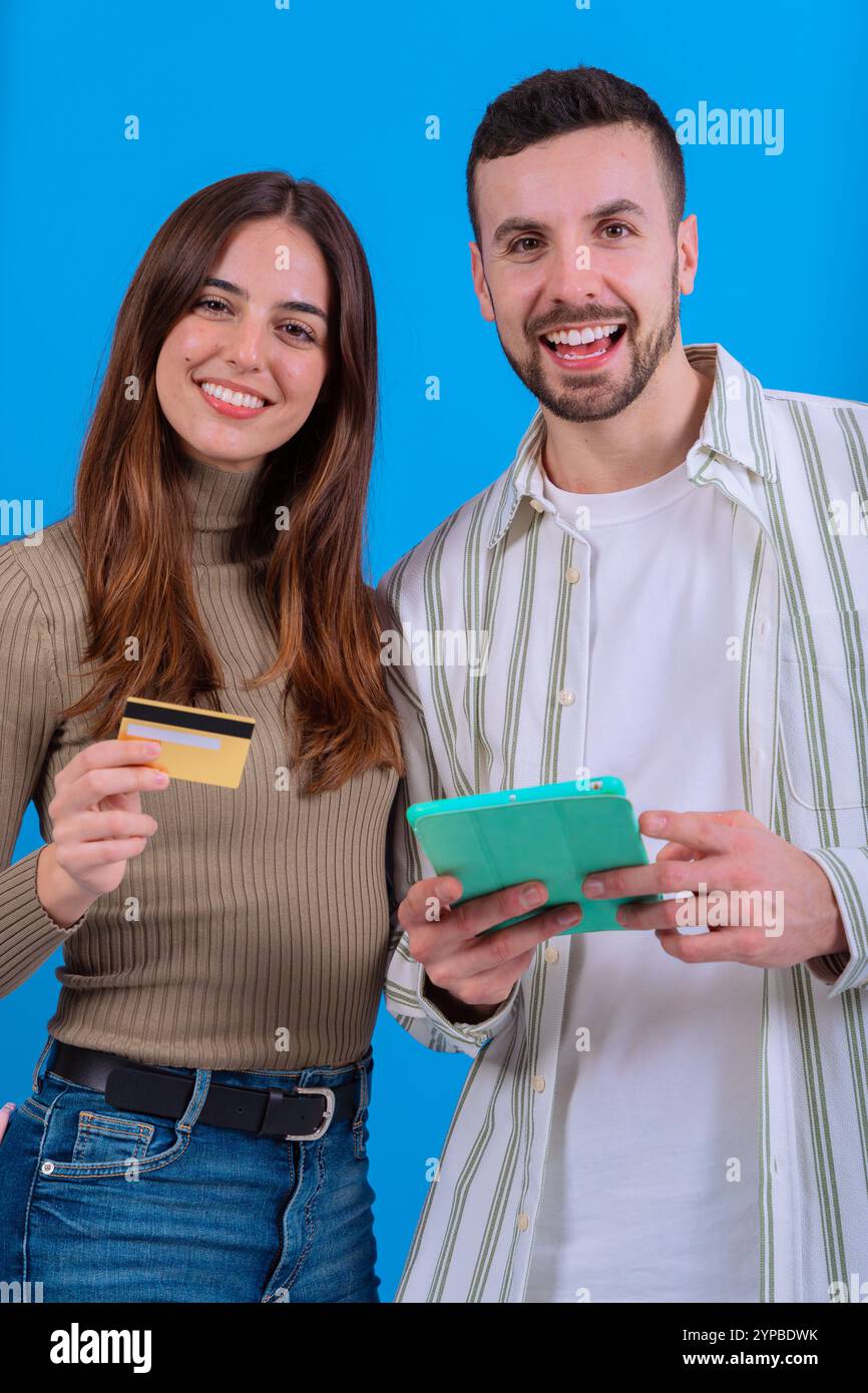 Couple souriant avec carte de crédit et tablette. Vertical Banque D'Images