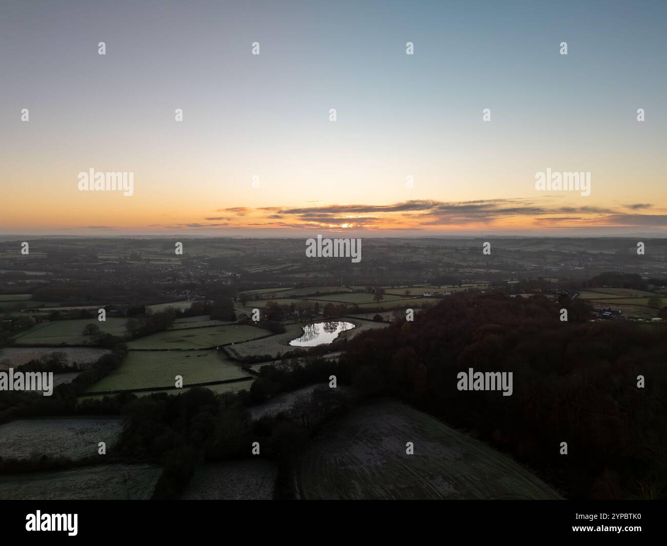 Vue aérienne d'un beau lever de soleil sur les champs et un petit village dans la campagne anglaise Banque D'Images