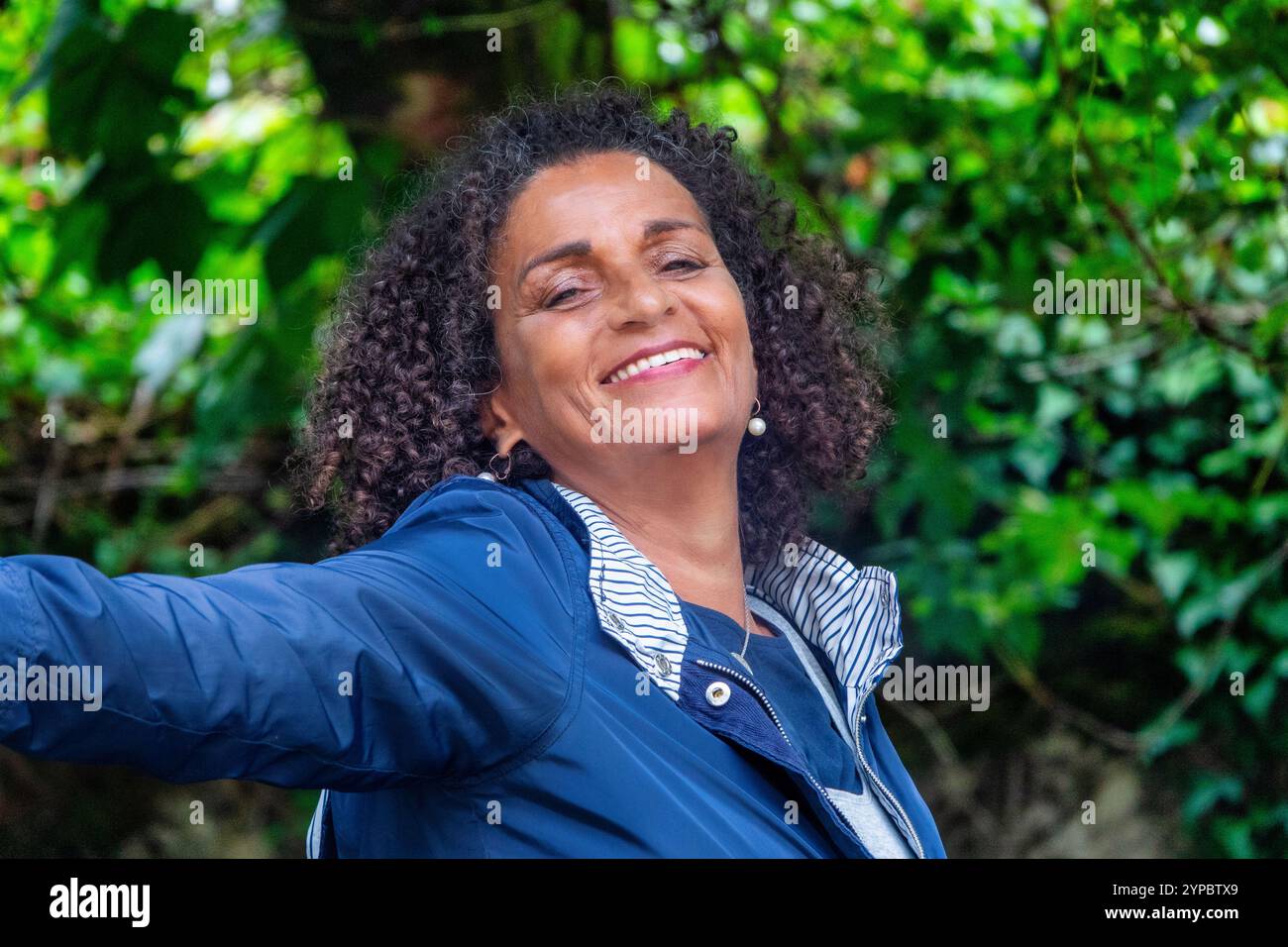 Belle et souriante femme sud-américaine d'âge moyen avec les bras grands ouverts Banque D'Images