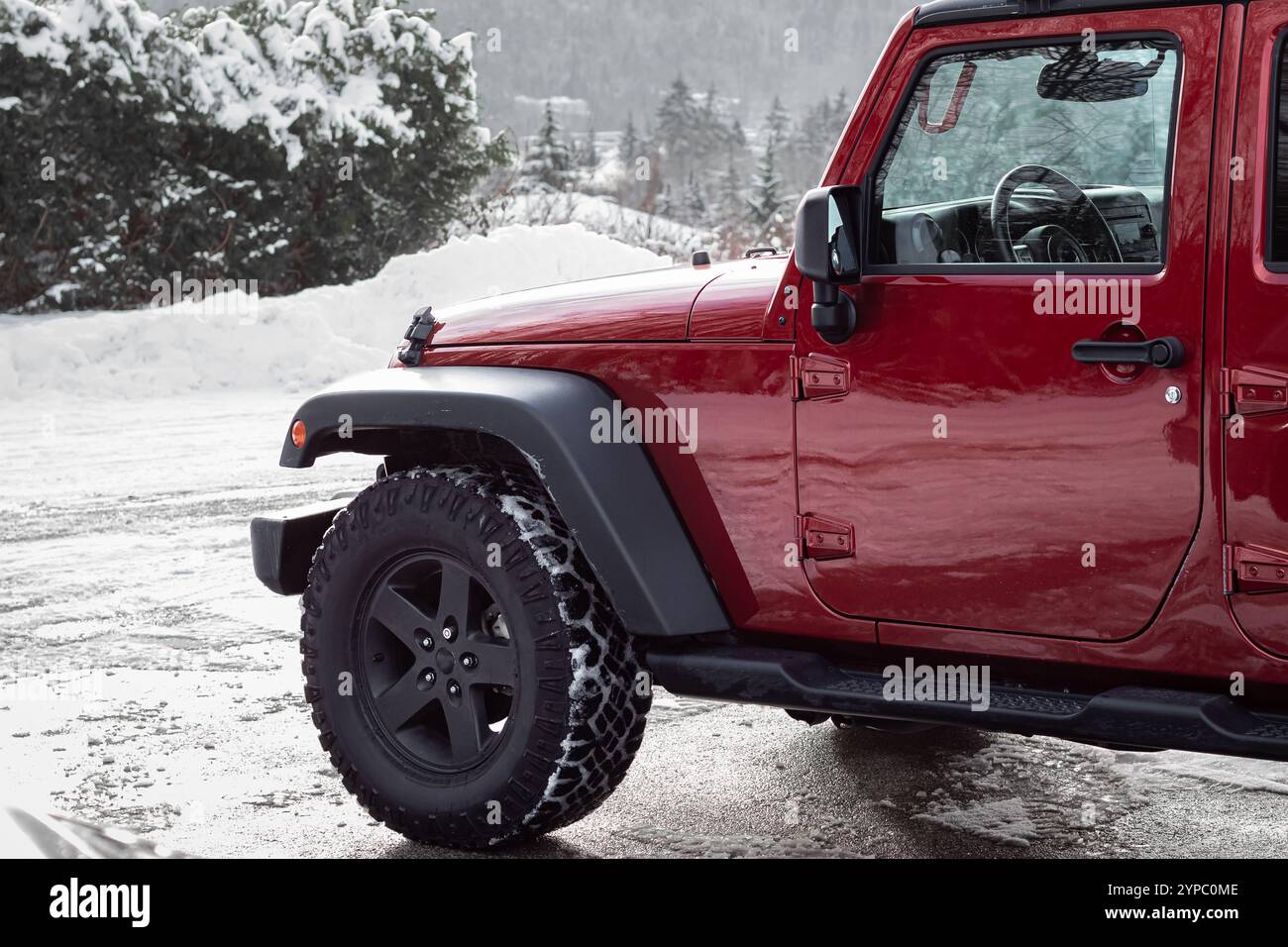 Gros plan d'une Jeep rouge en hiver. Roue avant d'un camion 4x4 aventures garé à l'extérieur. Camion hors route dans la glace épaisse d'hiver et la neige gelée. Personne Banque D'Images Gros plan d'une Jeep rouge en hiver. Roue avant d'un camion 4x4 aventures garé à l'extérieur. Camion hors route dans la glace épaisse d'hiver et la neige gelée. Personne Banque D'Images