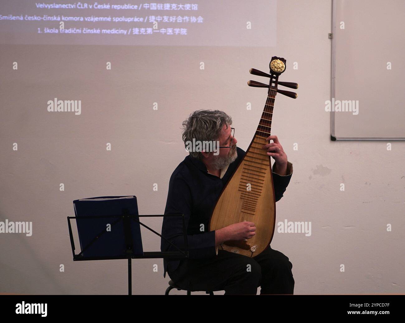 Prague, République tchèque. 28 novembre 2024. Un homme joue du pipa d'instrument de musique traditionnel chinois lors d'un événement sur la médecine traditionnelle chinoise (MTC) à Prague, en République tchèque, le 28 novembre 2024. L’événement sur la médecine traditionnelle chinoise (MTC) s’est tenu ici jeudi pour promouvoir le bien-être et les échanges culturels, tout en célébrant le 75e anniversaire de l’établissement des relations diplomatiques entre la Chine et la République tchèque. Crédit : Dana Kesnerova/Xinhua/Alamy Live News Banque D'Images