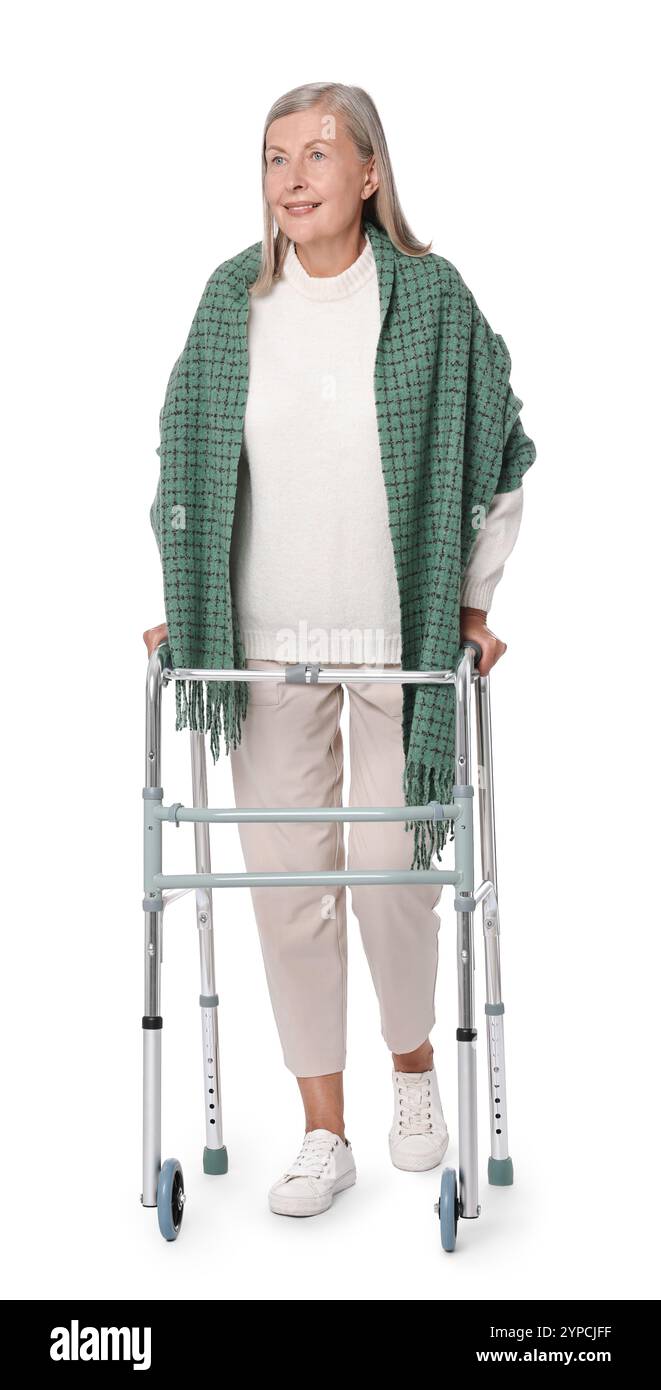 Femme senior utilisant le cadre de marche sur fond blanc Banque D'Images