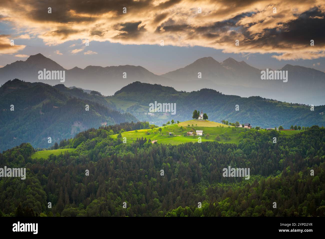 Sveti Tomaz, Slovénie. Levez le soleil en skiant sur les Alpes de Kamnik Savinja et la célèbre église perchée sur une colline. Banque D'Images