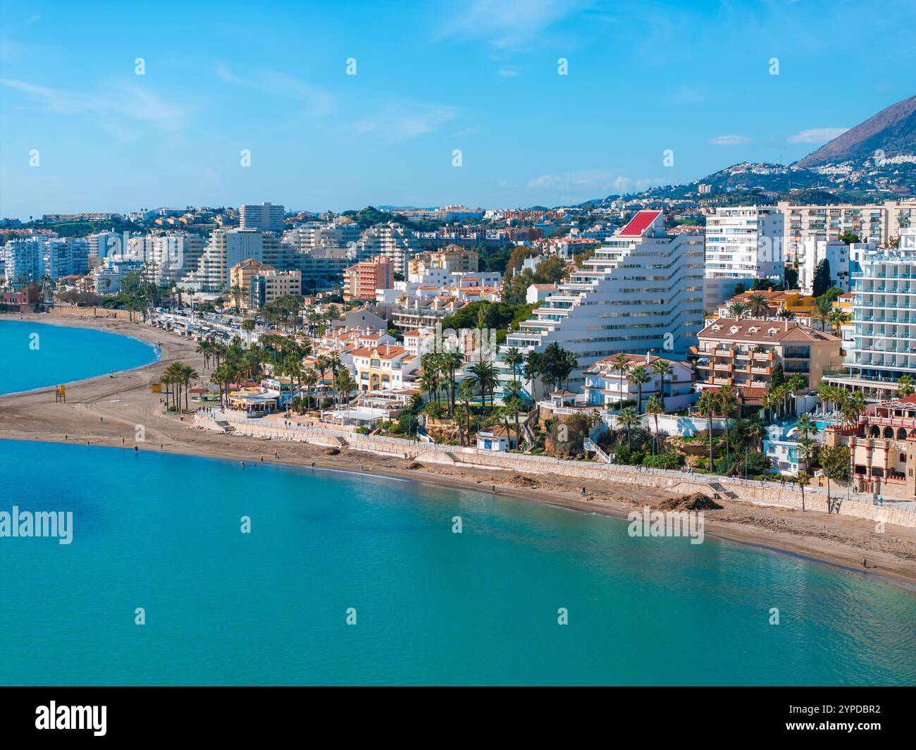 Vue aérienne de Benalmadena, Espagne, avec un bâtiment en forme de pyramide avec un toit rouge, des plages de sable, des palmiers et des gratte-ciel modernes. Banque D'Images