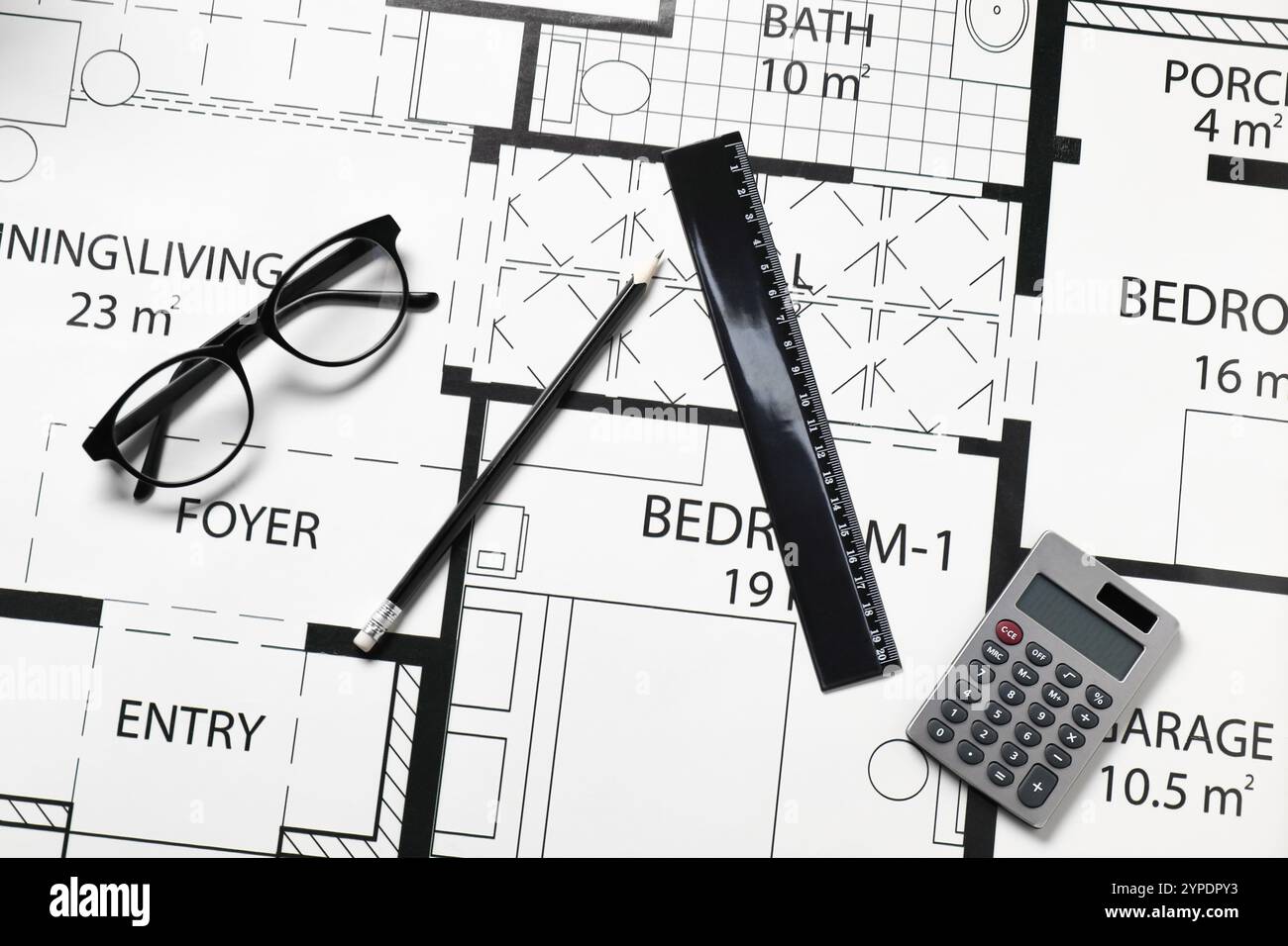 Règle, lunettes, calculatrice et crayon sur différents dessins architecturaux, vue de dessus Banque D'Images