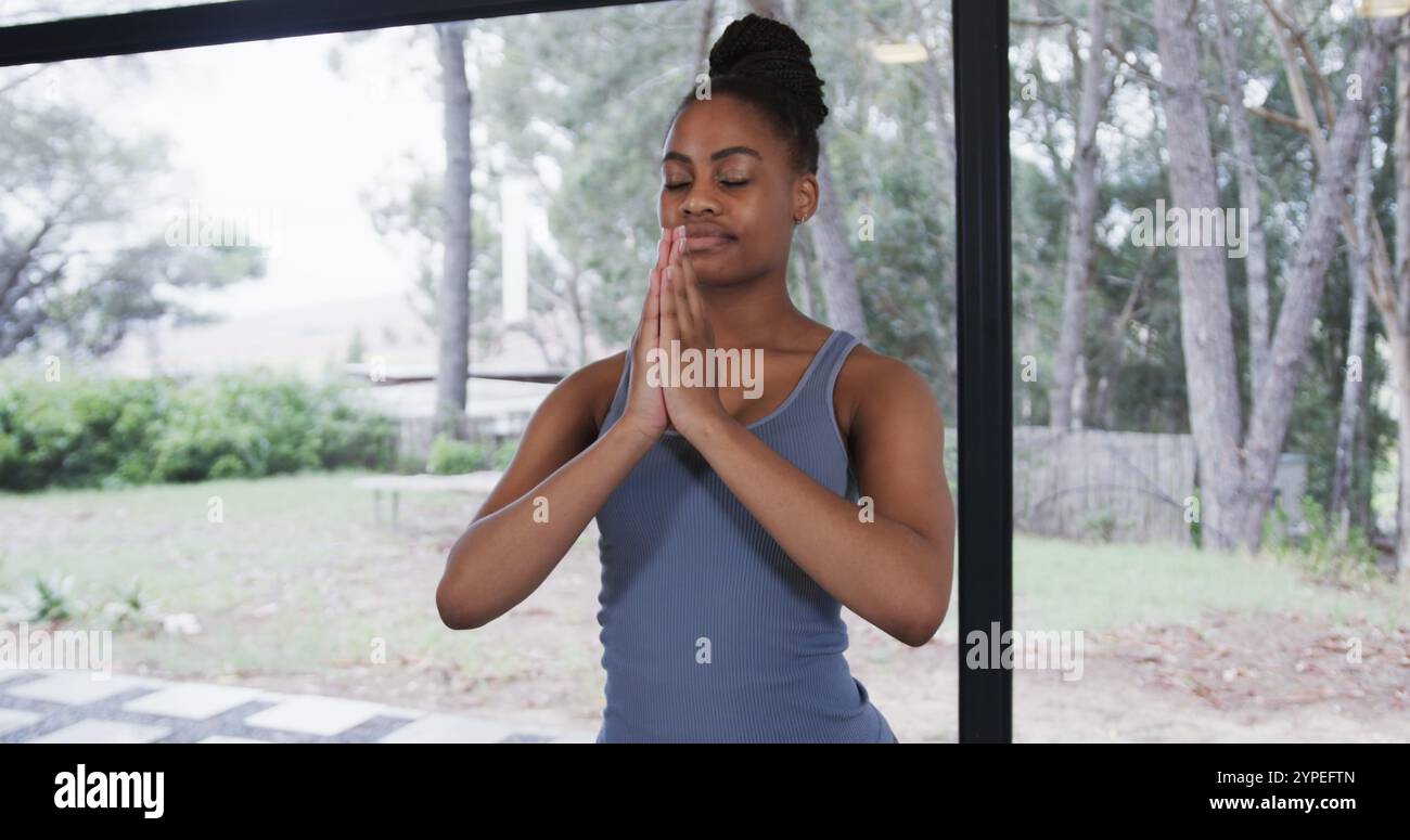 Portrait d'une femme afro-américaine méditant dans un studio de yoga Banque D'Images