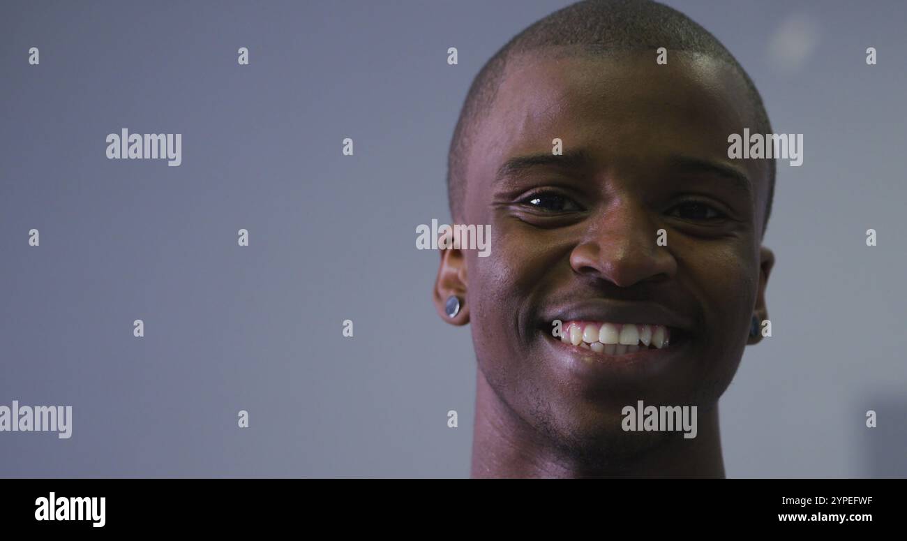 Portrait d'un danseur masculin moderne biracial, vêtu de vêtements noirs, regardant la caméra Banque D'Images