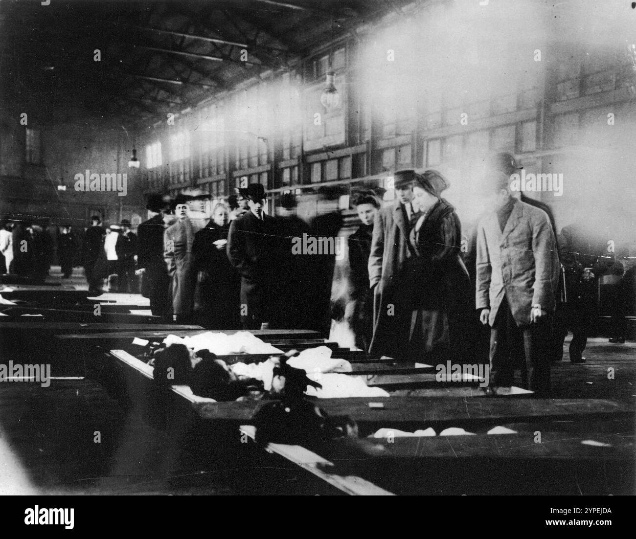 Les gens de la morgue de la jetée de la 26e rue marchent devant des rangées de cercueils ouverts, tentant d'identifier les victimes de l'incendie du Triangle, mars 1911. L'incendie de l'usine Triangle Shirtwaist a été l'un des pires accidents industriels de l'histoire des États-Unis. Un incendie s'est déclaré au 10ème étage de l'immeuble Asch. Les issues de secours étaient verrouillées, l'issue de secours était inadéquate et les échelles des pompiers n'étaient pas assez longues. 146 personnes ont été tuées, dont 62 ont sauté sur leur mort pour éviter les flammes. Banque D'Images