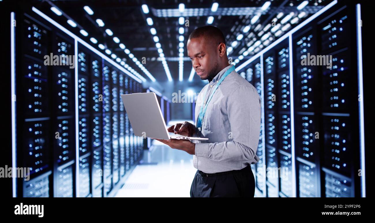 Heureux ingénieur dans la salle de serveurs de centre de données configurant la technologie IA Banque D'Images