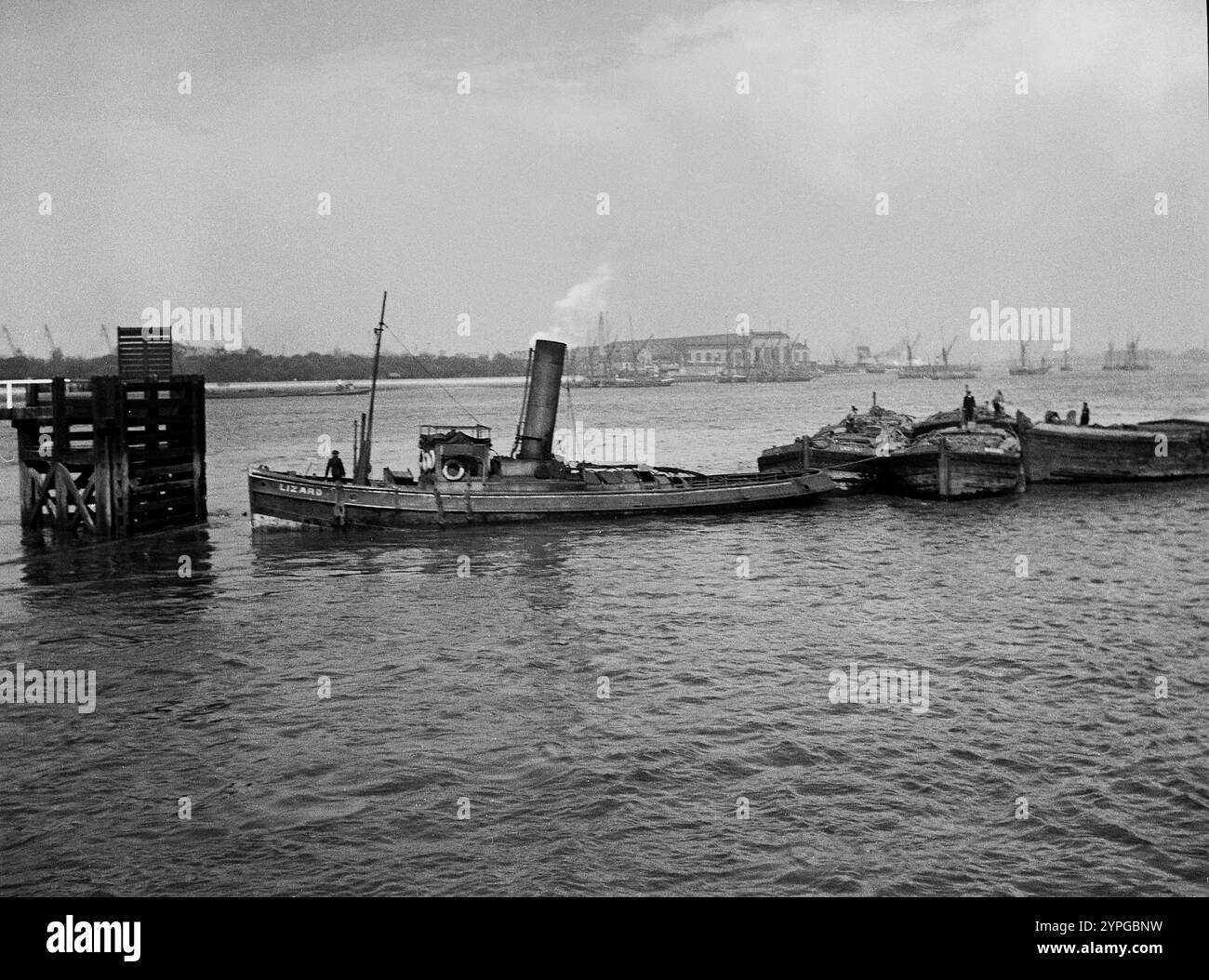Le remorqueur Lizard attaché à des barges sur la Tamise à Woolwich, années 1930 Banque D'Images