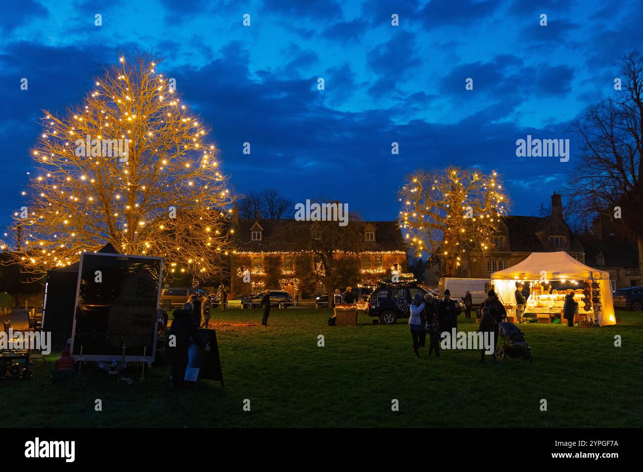 Fin de nuit shopping de Noël dans le village de Broadway dans les Cotswolds en 2024, avec les belles décorations de Noël sur l'exposition Banque D'Images