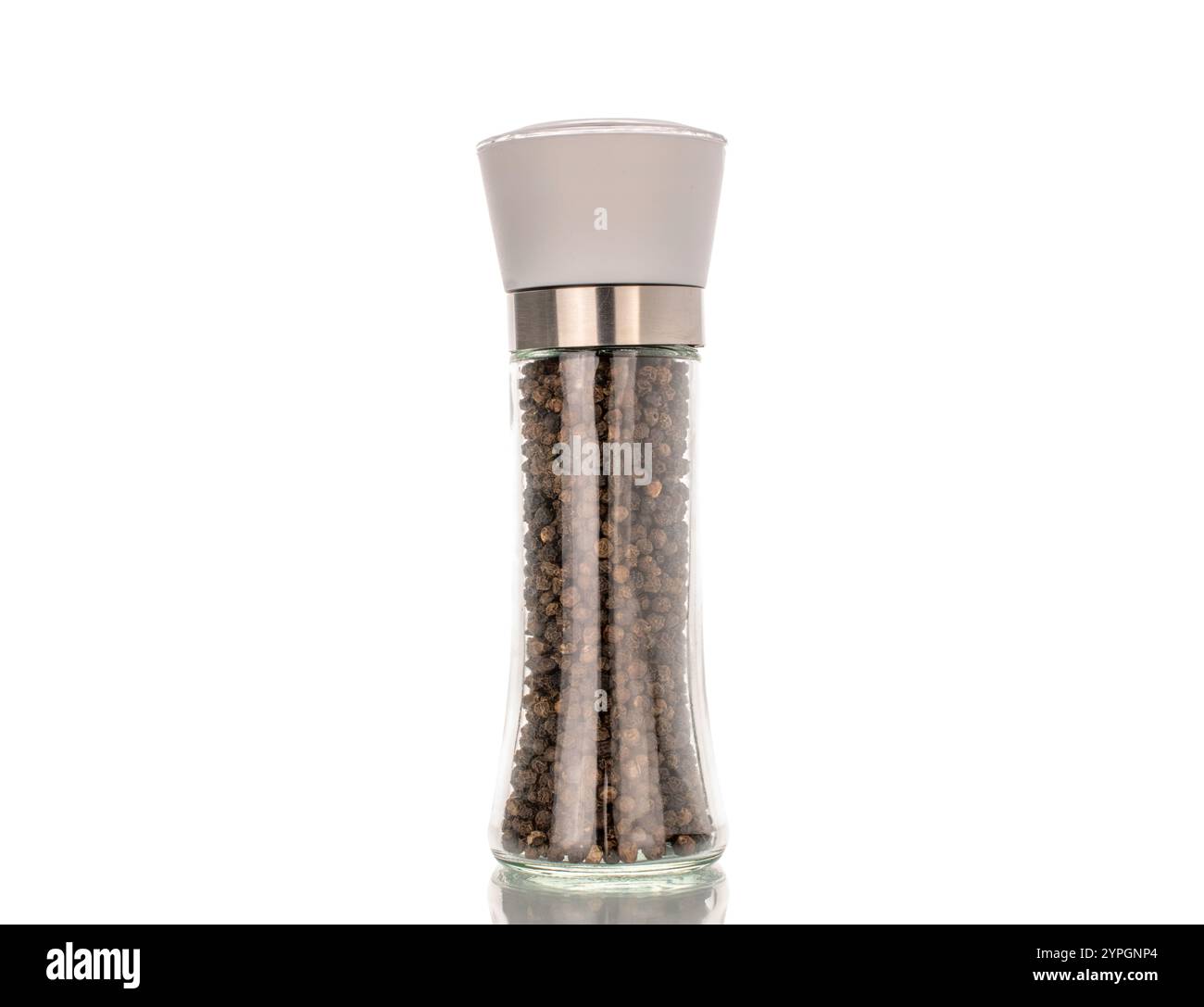 Grains de poivre noir dans un moulin en verre, macro, isolé sur fond blanc Banque D'Images