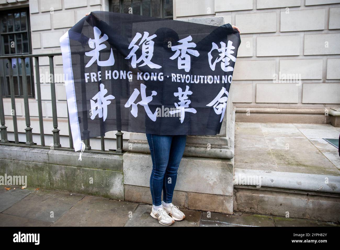 Londres, Royaume-Uni, 30 novembre 2024. Un manifestant brandit une pancarte de protestation. Une manifestation organisée par les syndicats a lieu devant l'ambassade de Chine dans le centre de Londres. Les manifestants appellent à la libération de 45 activistes pro-démocratie emprisonnés récemment condamnés à Hong Kong en vertu de la loi sur la sécurité nationale de la ville. Crédit : James Willoughby/ALAMY Live News Banque D'Images