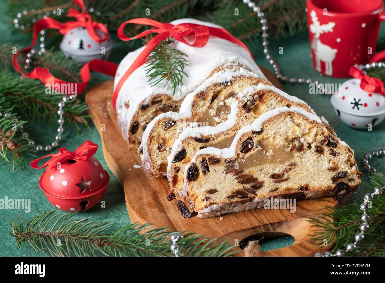 Noël Stollen allemand avec massepain et fruits secs dans du sucre en poudre sur planche de bois. Gâteries traditionnelles en Allemagne Banque D'Images