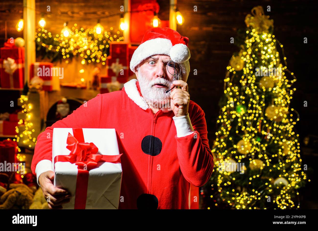 Le Père Noël tient présent. Je te souhaite un joyeux Noël. Homme souriant dans le chapeau de Père Noël tenir la boîte cadeau cadeau de cadeau. Père Noël avec boîte cadeau de Noël. Joyeux Christma Banque D'Images