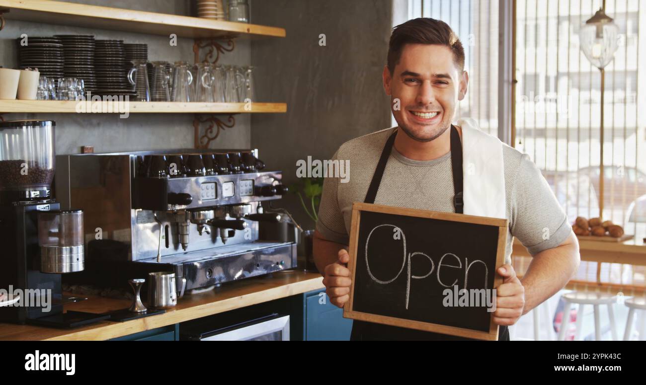 Portrait de propriétaire heureux avec tableau noir au comptoir dans le café Banque D'Images